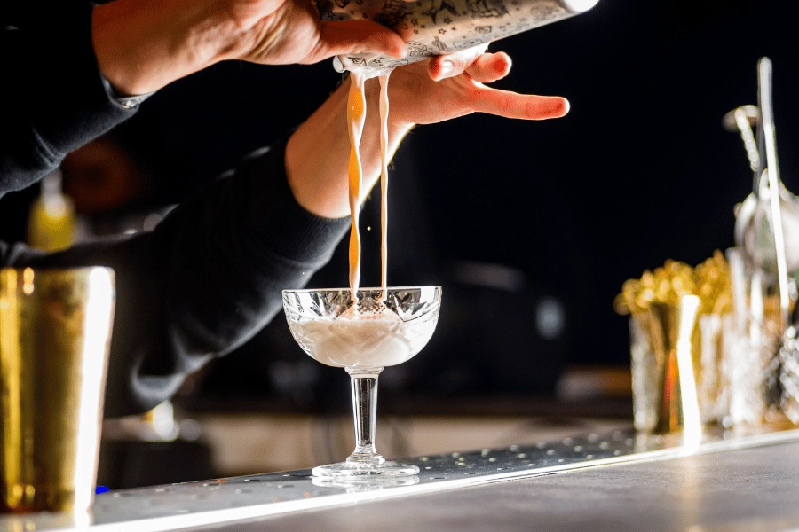 bartender pouring a cocktail at a speakeasy